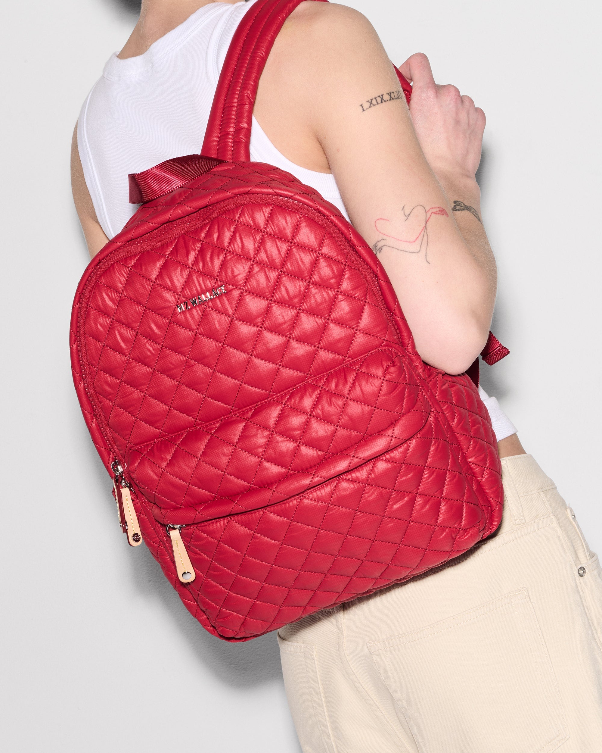 Personal wearing MZ Wallace Small Red Backpack on back