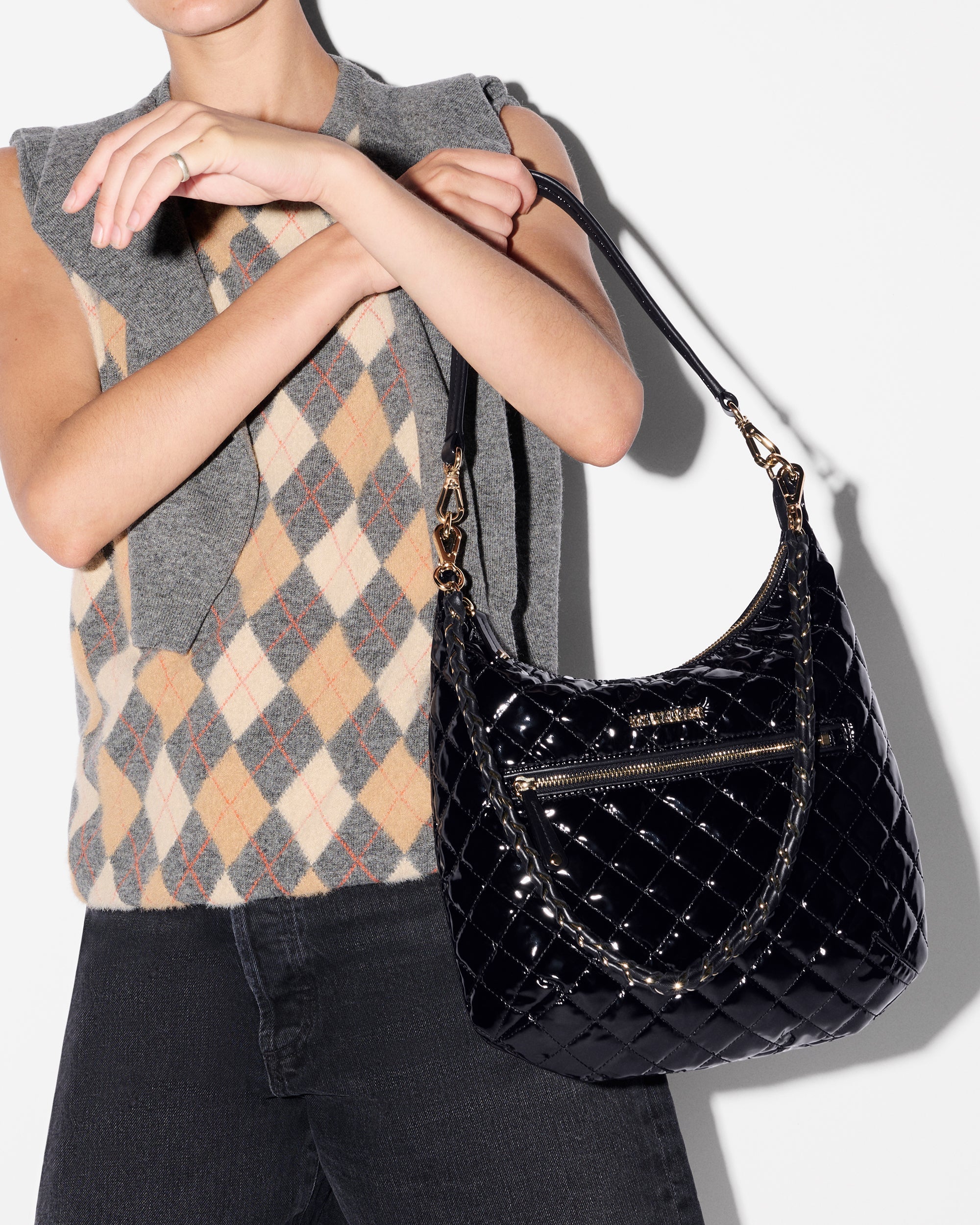 Woman putting MZ Wallace Black Glossy Shoulder Bag on her shoulder