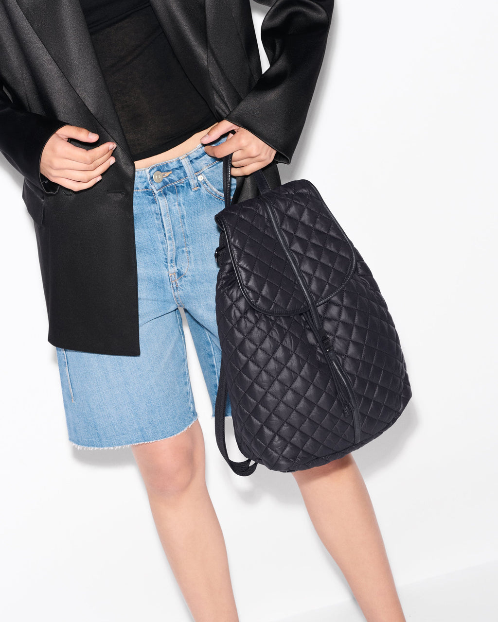 Woman holding MZ Wallace Black Spacious Backpack in hand