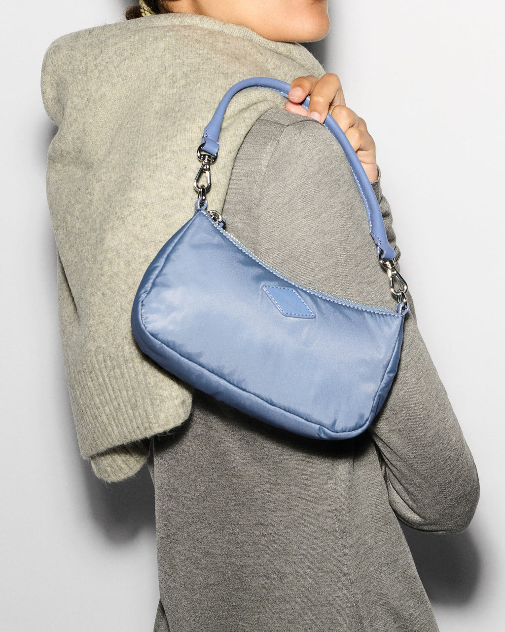 Woman holding MZ Wallace Mini Blue Purse to shoulder